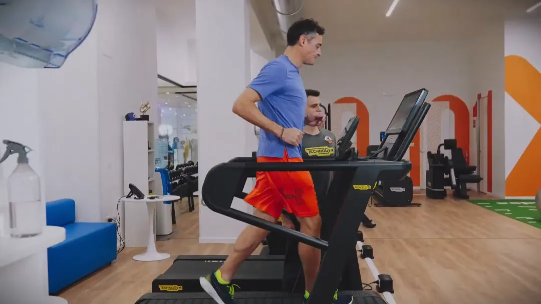 Un fisioterapista di k·medical segue una paziente in palestra